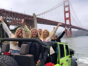 Private San Francisco Jeep tour group posing with the Golden Gate Bridge